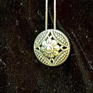 Sterling silver necklace with flower motif pendant.